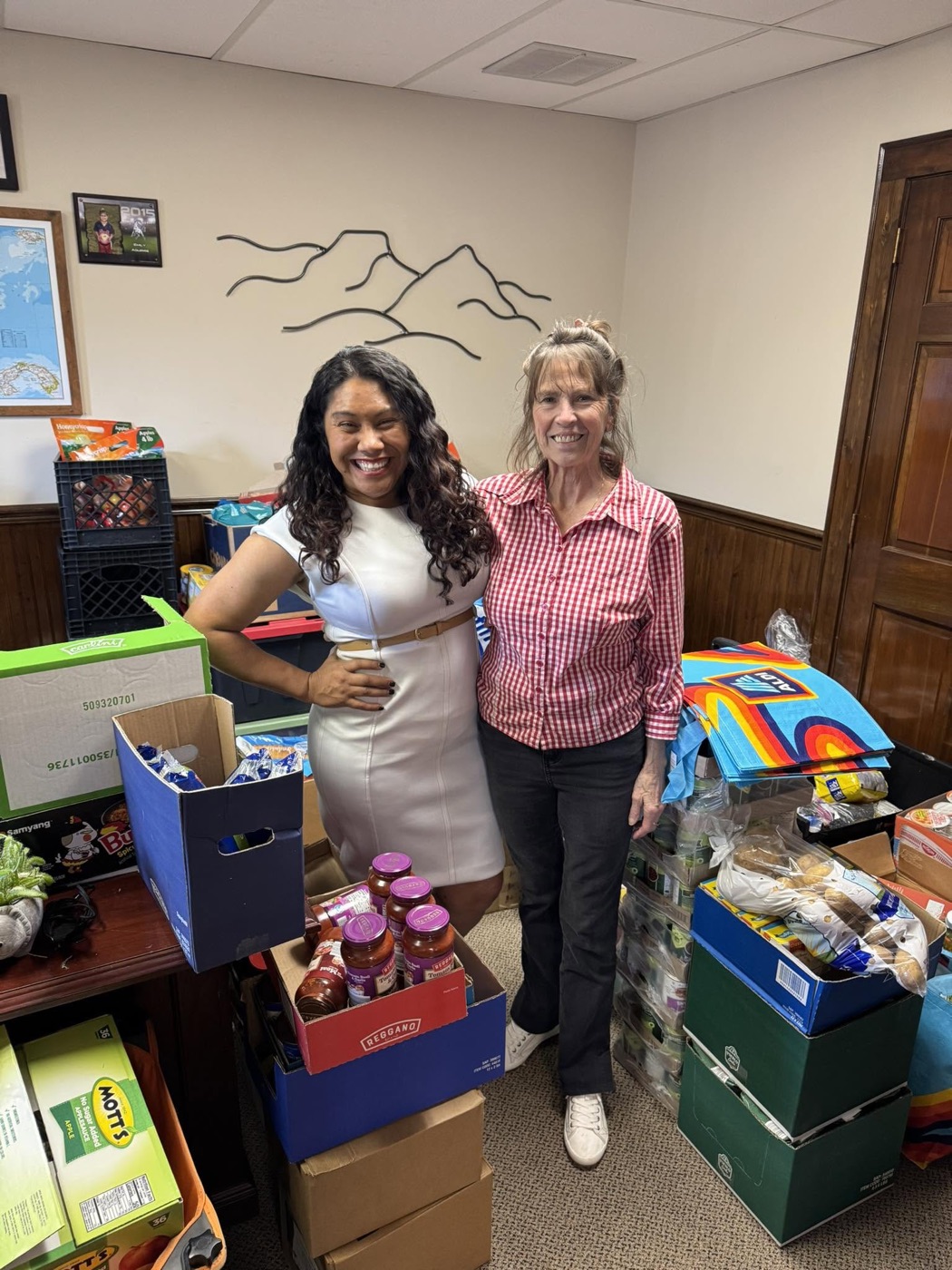 Sandra Aguirre with a volunteer surrounded by donated food